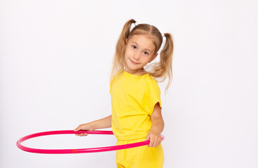 Little girl in a yellow dress is holding a hoop Isolated on white background.