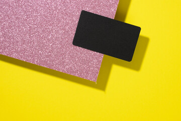 blank black rectangular business card on a creative background from sheets of paper with shadow, yellow sheets