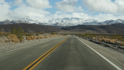Road trip to Death Valley, driving auto in California, USA. Hitchhiking traveling in America. Highway, mountains and dry desert, arid climate wilderness. Passenger POV from car. Journey to Nevada.