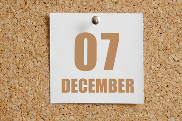 december 07. 07th day of the month, calendar date.White calendar sheet attached to brown cork board.Winter month, day of the year concept