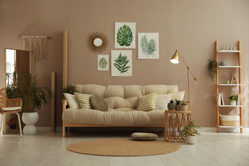Stylish living room interior with comfortable sofa and beautiful pictures on wall