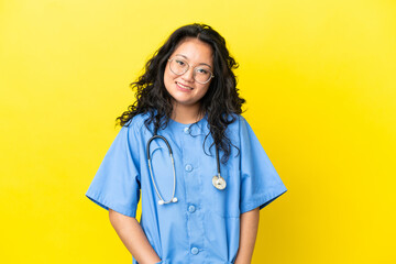 Young surgeon doctor asian woman isolated on yellow background laughing