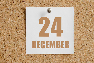 december 24. 24th day of the month, calendar date.White calendar sheet attached to brown cork board.Winter month, day of the year concept