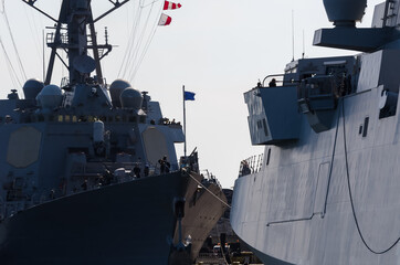 WARSHIPS - An Italian frigate and an American destroyer moored at a seaport wharf 

