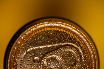 tin can of beer on a yellow background view from above close up.