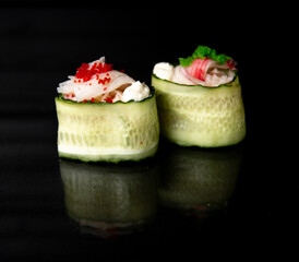 japanese cuisine. guncan in cucumber with sauce on a black background