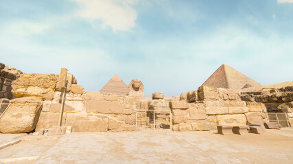 Great Sphinx with pyramid in background on a beautiful blue sky day in Giza, Cairo, Egypt.