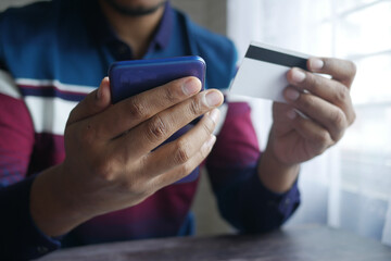 young man typing credit card detail on smart phone 