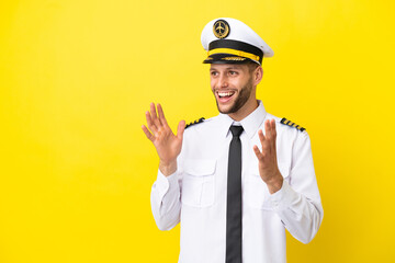 Airplane caucasian pilot isolated on yellow background with surprise facial expression