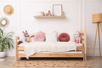 Cute child's room interior with comfortable bed and toys