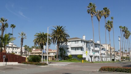 Fototapeta na wymiar Houses on suburban street in California USA, Oceanside. Generic buildings in residential district near Los Angeles. Real estate property exterior. Tropical gardens, palms near typical american homes.