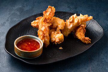 deep fried almond shrimp tempura on black plate