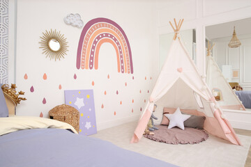 Stylish room with comfortable bed and teepee tent for kids. Interior design