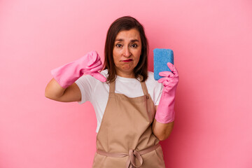 Middle age caucasian woman cleaning home isolated on pink background showing a dislike gesture, thumbs down. Disagreement concept.