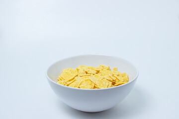 Plate with cornflakes on a white background. Healthy and tasty breakfast.