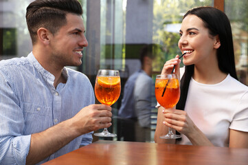 Happy couple with Aperol spritz cocktails outdoors