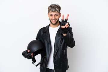 Young man with a motorcycle helmet isolated on white background smiling and showing victory sign