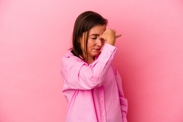 Middle age caucasian woman isolated on pink background having a head ache, touching front of the face.