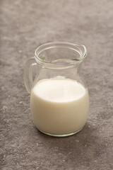 Jug of fresh milk close up on gray concrete