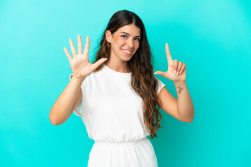 Fototapeta premium Young caucasian woman isolated on blue background counting seven with fingers