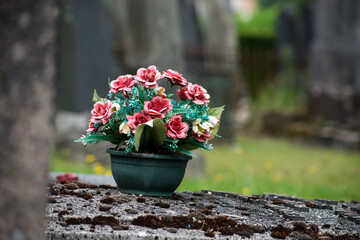 Fototapeta na wymiar closeup of artificial flowers on tomb in cemetery