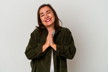 Middle age caucasian woman isolated on white background holding hands in pray near mouth, feels confident.