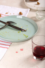 Empty dirty plate with cutlery after eaten food in restaurant on table