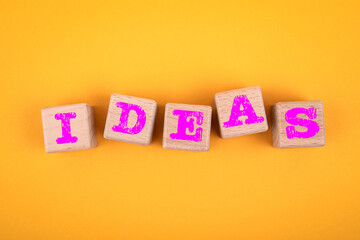 Ideas. Creativity and success concept. Wooden blocks on a yellow background