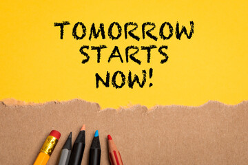 Tomorrow starts now. Colored pencils on a cardboard and yellow background - obrazy, fototapety, plakaty