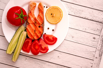 fish steak on a white plate with vegetables