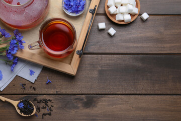 Composition with tea and cornflowers on wooden table, flat lay. Space for text