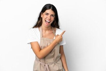 Restaurant waiter over isolated white background surprised and pointing side