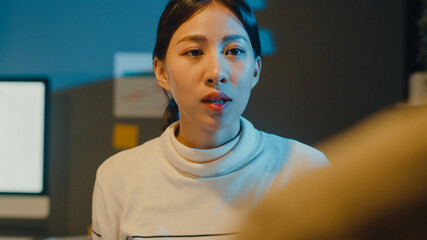 Fototapeta premium Happy young Asia businessmen and businesswomen meeting brainstorming some new ideas about project to his partner working together planning success strategy enjoy teamwork in small modern night office.
