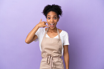 Restaurant waiter latin woman isolated on purple background making phone gesture. Call me back sign