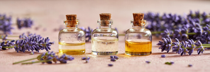 Panoramic header of bottles of essential oil with fresh lavender flowers - obrazy, fototapety, plakaty