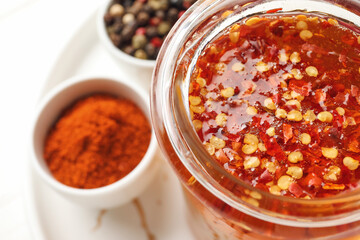 Jar of hot honey and spices on light background, closeup