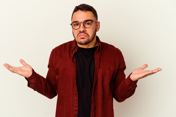Young caucasian man isolated on white background doubting and shrugging shoulders in questioning...