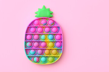 Colorful antistress sensory toy fidget push pop it on pink background, top view - obrazy, fototapety, plakaty