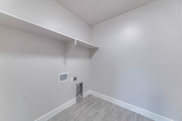 Renovated empty room with a long wooden shelf on a white wall