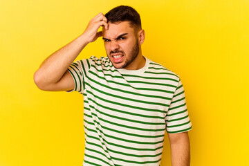 Young caucasian man isolated on yellow background forgetting something, slapping forehead with palm...