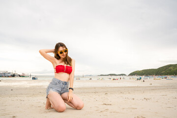
Portrait of a 20-30 year old woman walking traveling and play marine sports on a beach by the sea in Thailand.