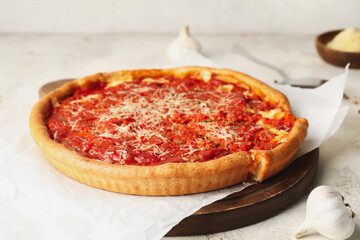 Tasty Chicago-style pizza on light background