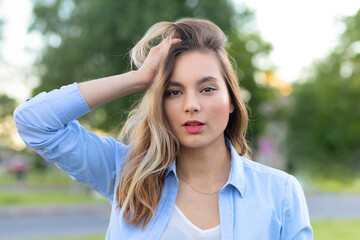 Fototapeta premium closeup portrait of beautiful brooding young woman face skin, attractive sexy girl outdoors, hand on head. emotional elegant female. teen with long hair