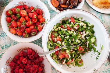 Homemade salad of fresh vegetables and fresh ripe berries