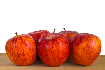 Orange red striped apples on wooden table close up isolated on white. Rustic style, selective focus, design element of grocery store sign or market with organic farming products. Gala apple variety.