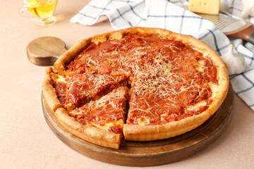 Board with tasty Chicago-style pizza on color background