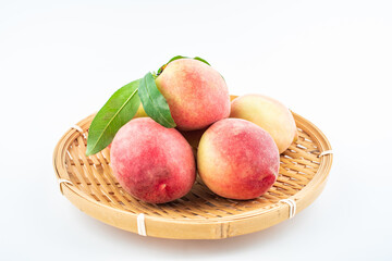 Fresh peaches in a pot on white background