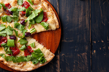 Brazilian-style pizza with mozzarella, sun-dried tomatoes and arugula. Top view. Copy space