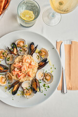 risotto with shrimps, mussels, served with a glass of white wine and a basket of bread