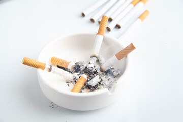 White ashtray with a cigarette. Smoking